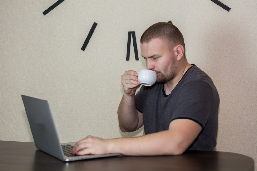 Java developer drinking coffee while coding at a modern desk